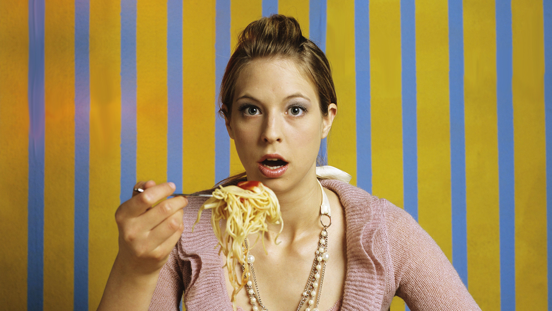 Young woman eating spaghetti