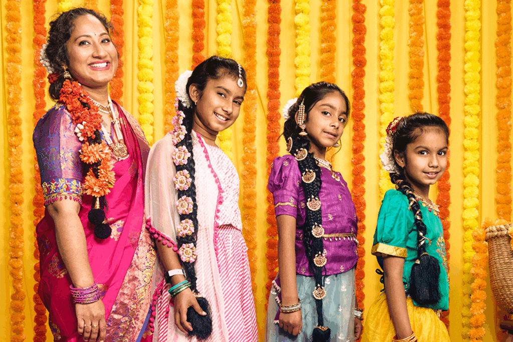 A yellow background with four young female children from a South-East Asian background.